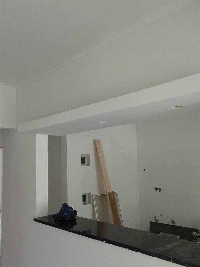 Construção de uma cozinha com ilha,um pequeno balcão com focos.