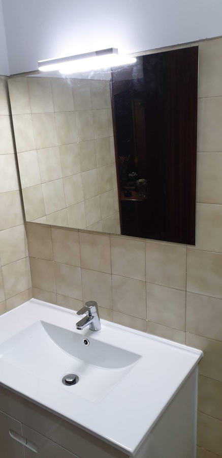 Colocação de espelho com luminária moderna