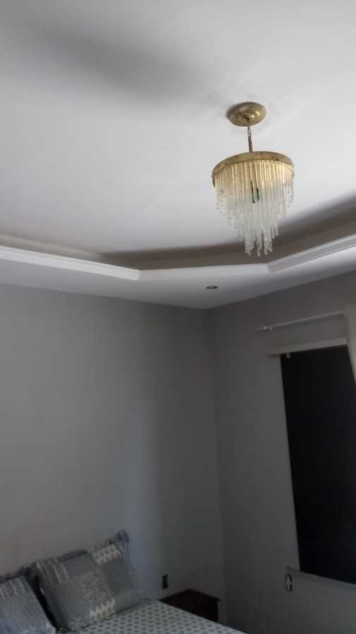 Luz indireta com lustre de chapa dourada e teto com rebaixamento parcial de gesso.