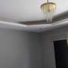 Luz indireta com lustre de chapa dourada e teto com rebaixamento parcial de gesso.